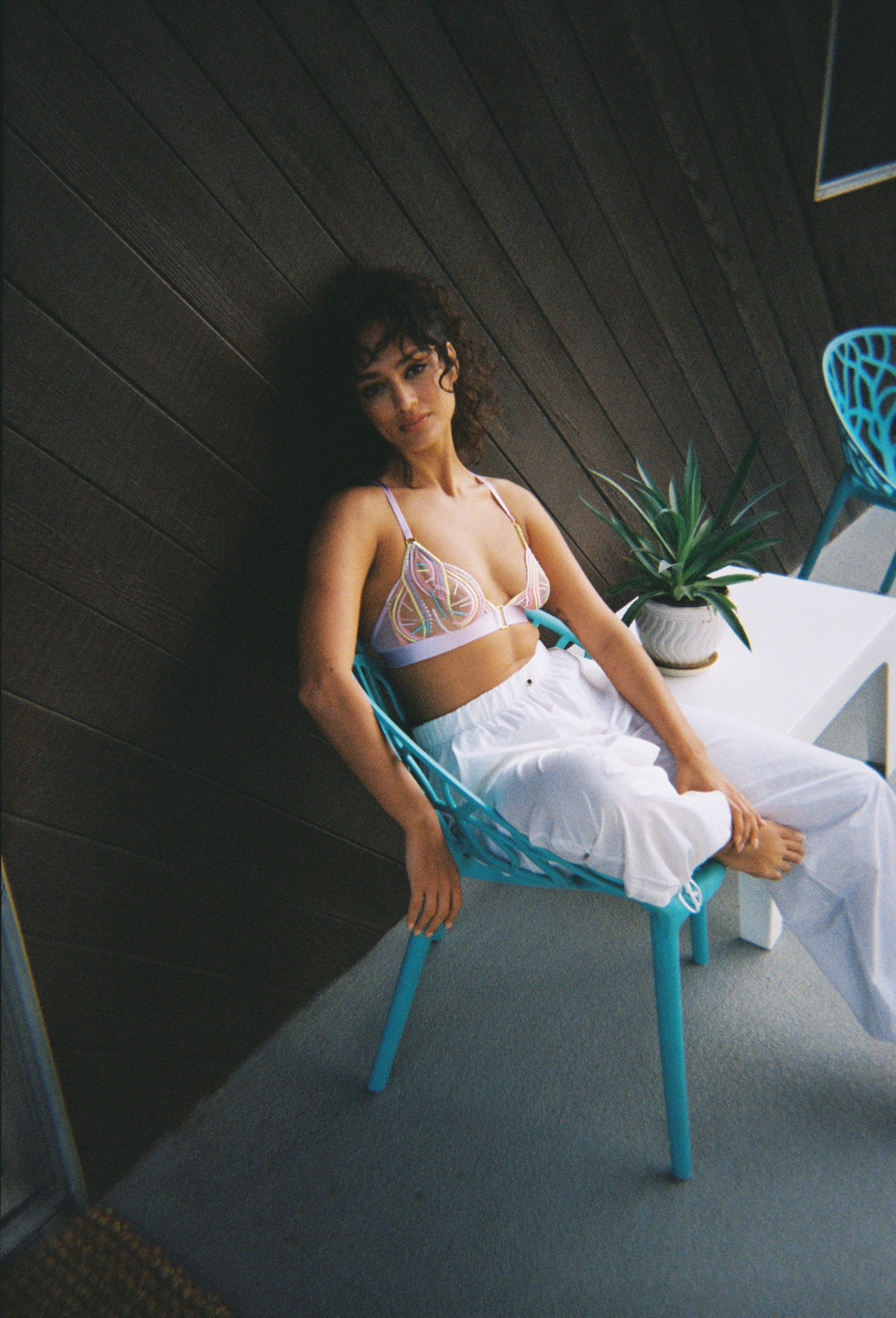 LIFESTYLE SHOT GIRL SAT ON CHAIR PURPLE BRALETTE