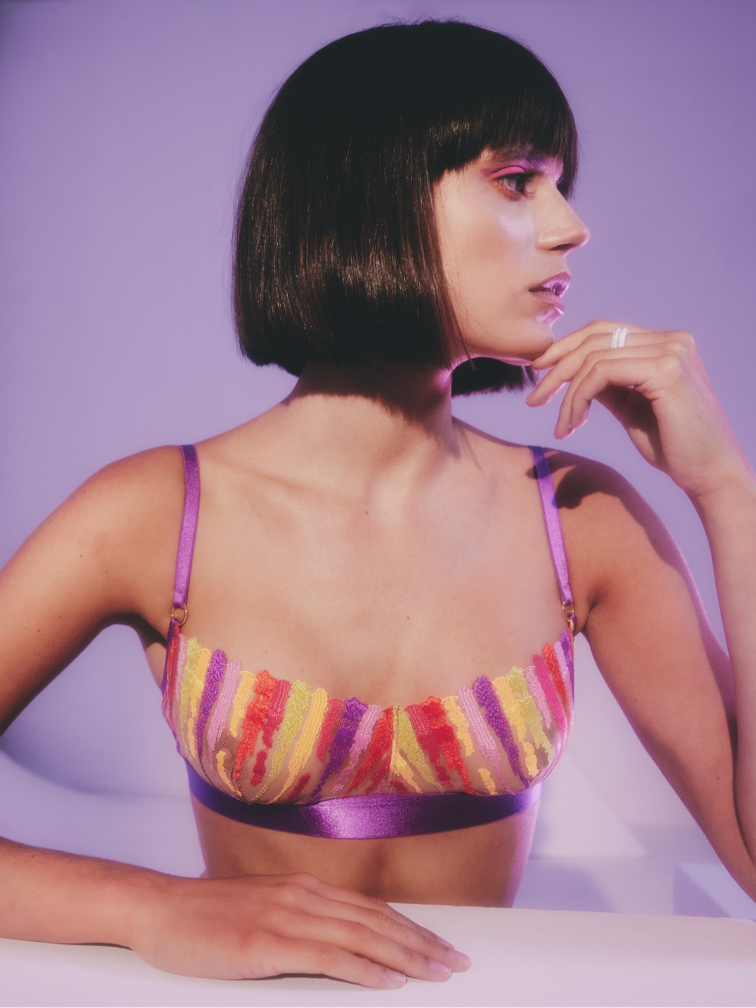MODEL LOOKING TO THE SIDE WEARING COLORFUL PURPLE LACE BALCONETTE BRA TOP