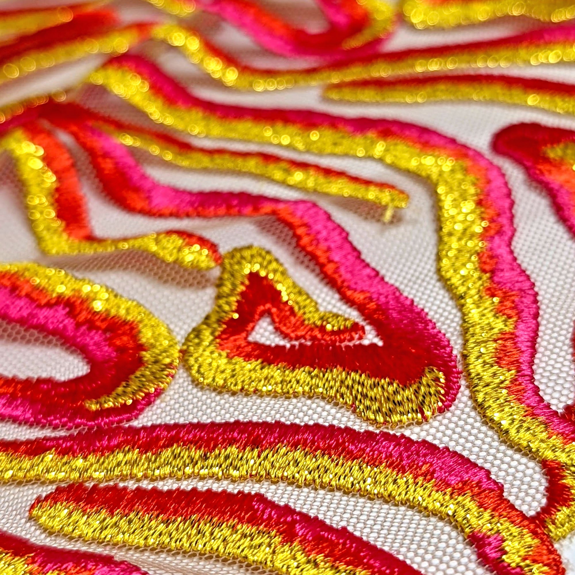 EMBROIDERY LACE WITH PINK, RED AND YELLOW STITCHES ON A SHEER TULLE BASE FABRIC